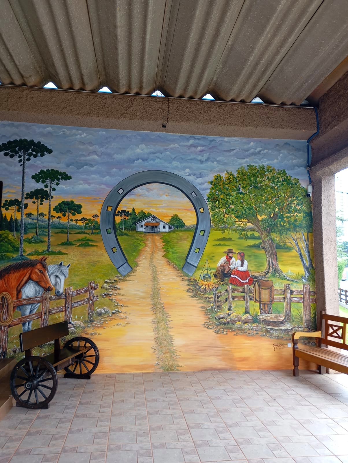 Pintura mural na entrada do CTG Porteira Aberta — obra que retrata a essência gaúcha